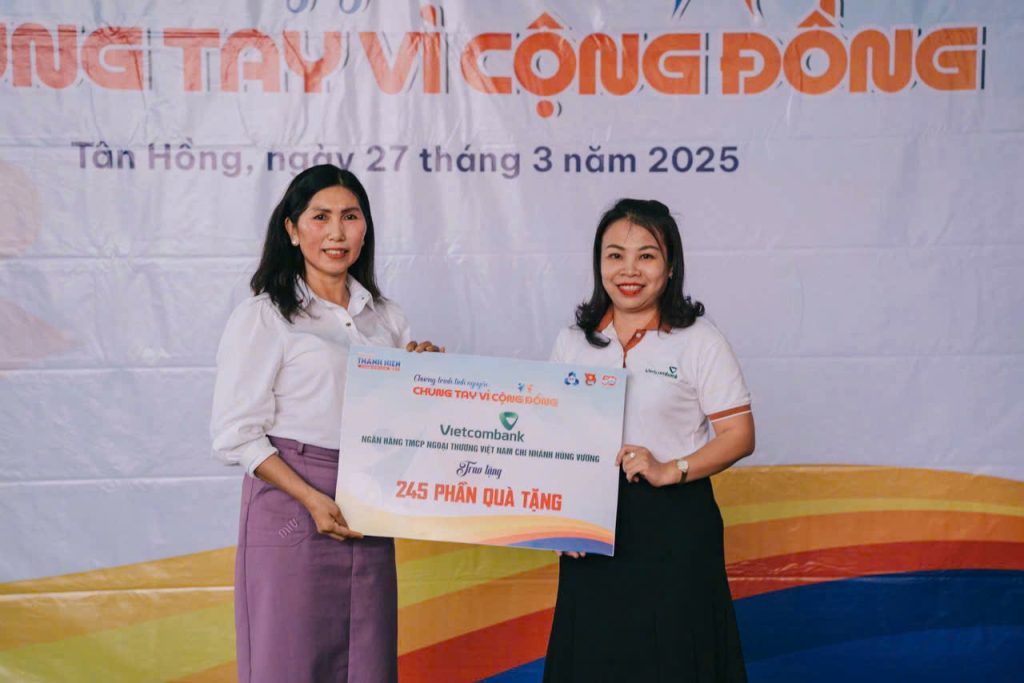 đại diện ngân hàng Vietcombank lên trao bảng tượng trưng cho cô Lê Thị Vân - Bí thư chi bộ hiệu trưởng trường mầm non Sơn Ca